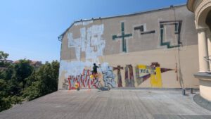 Das Bild zeigt die mit Graffitis beschmierte Fassade der Potsdamer Stadtverwaltung die von WarDaWas professionell von einem Industriekletterer gereinigt wird