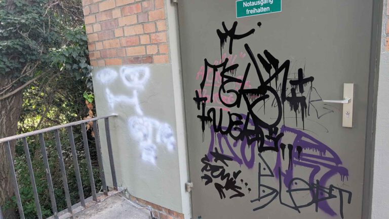 Das Foto zeigt eine mit Grafittis beschmierte Tür an der Bühne der Freundschaftsinsel Potsdam, vor der Graffitientfernung durch WarDaWas
