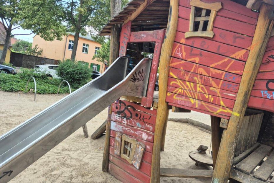 Das Foto zeigt ein mit Graffitis beschmiertes Kletterhaus aus Holz auf einem Spielplatz in Potsdam Babelsberg, bevor es professionell und umweltfreundlich von der Firma WarDaWas gereinigt wird.