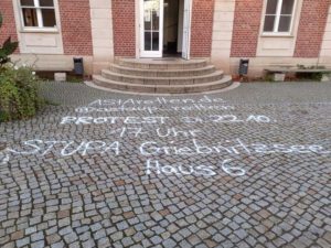 Das Bild zeigt den Eingangsbereich der Univeristät Potsdam, dessen Pflastersteine auf dem Boden mit Graffitis beschmirt wurden und dient als Referenzbild des Beitrags 'Von Tags bis Taubenkot: Ein Jahrzehnt Reinigungseinsätze für die Universität Potsdam' der Firma WarDaWas.