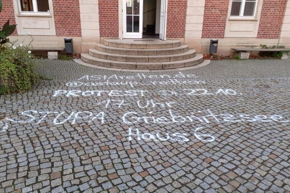Das Bild zeigt den Eingangsbereich der Univeristät Potsdam, dessen Pflastersteine auf dem Boden mit Graffitis beschmirt wurden und dient als Referenzbild des Beitrags 'Von Tags bis Taubenkot: Ein Jahrzehnt Reinigungseinsätze für die Universität Potsdam' der Firma WarDaWas.