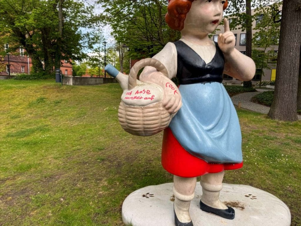 Das Bild zeigt eine mit Graffiti beschmierte Rotkäppchen-Statue auf dem Gelände der Universität Potsdam und bebildert den Beitrag 'Von Tags bis Taubenkot: Ein Jahrzehnt Reinigungseinsätze für die Universität Potsdam' der Firma WarDaWas.