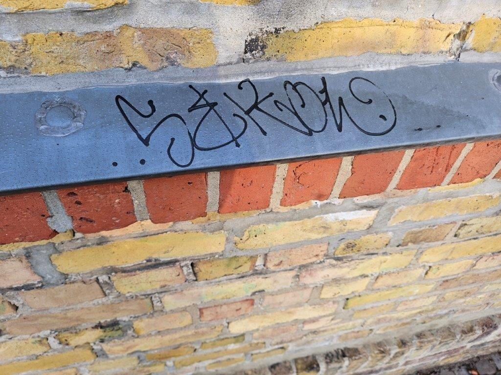 Eine mit Permanentmarker beschmierte Metallkante, bevor von WarDaWas eine Spezialreinigung durchgeführt wurde.