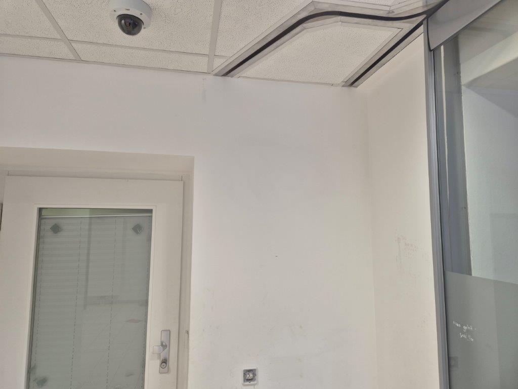 Eine weiße Wand im Innenraum einer Sparkasse, die von rotem Graffiti befreit wurde, nach der Graffiti-Entfernung durch WarDaWas