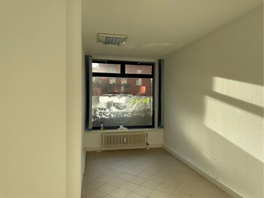 Das Bild zeigt ein mit Klebefolie beklebtes und mit Graffiti beschmiertes Fenster eines Bürogebäudes während der Entfernung durch WarDaWas