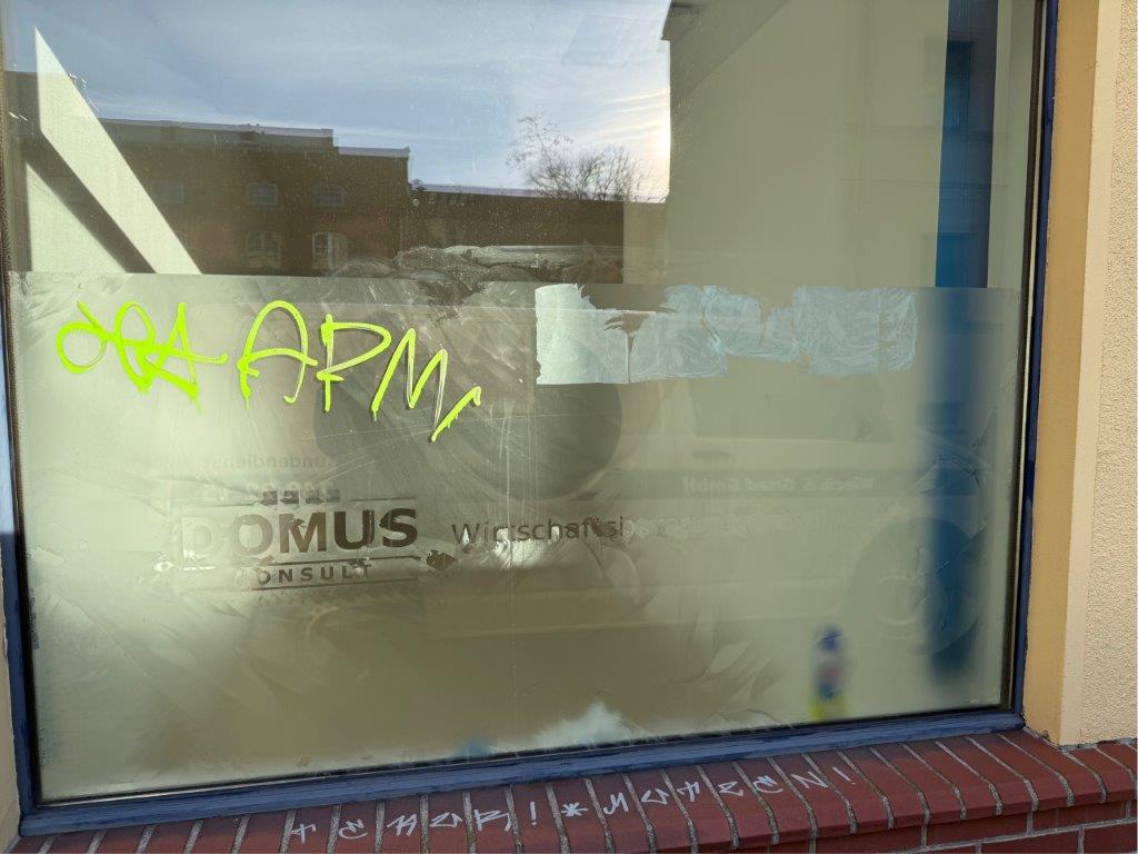Das Bild zeigt ein mit Klebefolie beklebtes und mit Graffiti beschmiertes Fenster eines Bürogebäudes vor der Entfernung durch WarDaWas