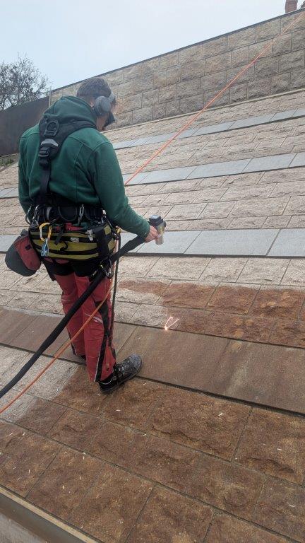 Detailaufnahme Laserreinigung auf Naturstein: Reinigungsgerät im Einsatz mit sichtbaren Funken, Rathenow