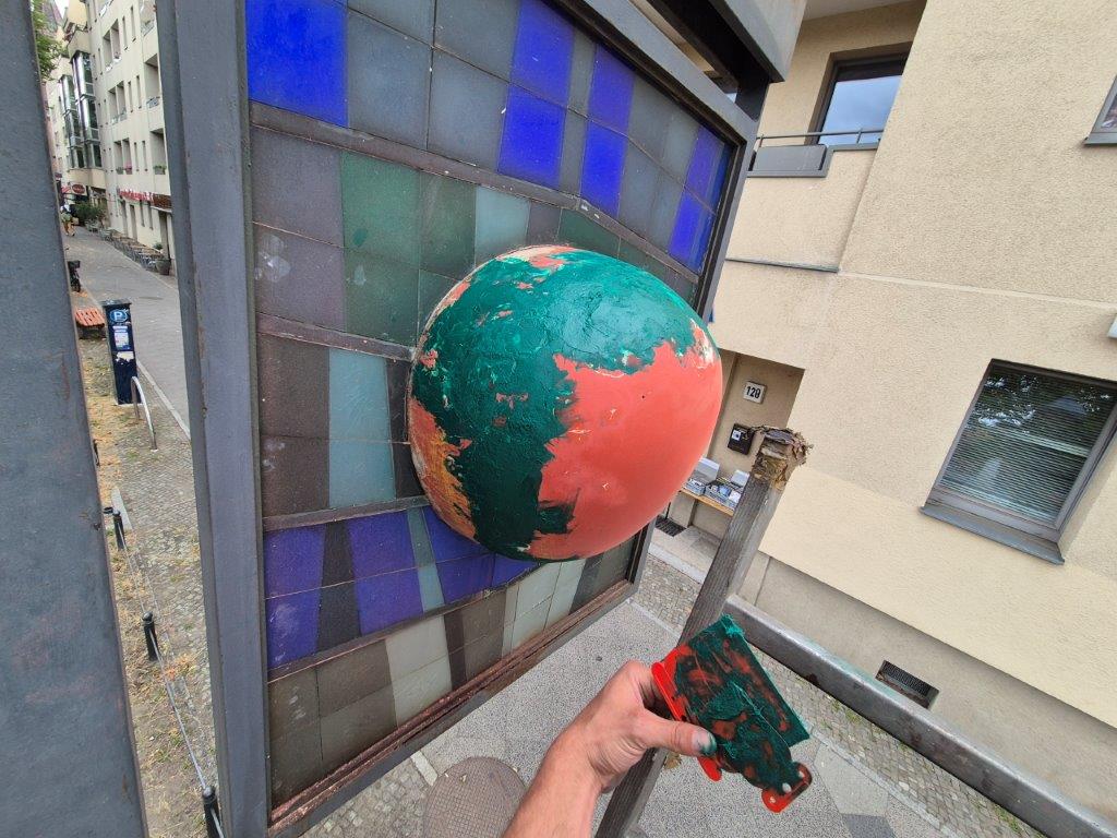 Zwischenstand bei der Reinigung und Farbausbesserung des Kunstobjekts Apfel in Babelsberg